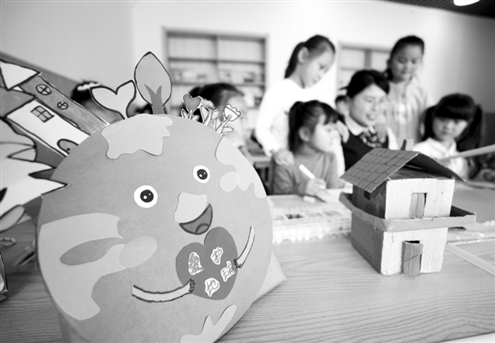 4月22日是世界地球日,临沂市郯城县郯城街道官塘幼儿园的老师教孩子们利用废旧物品等制作环保玩具。新华社发